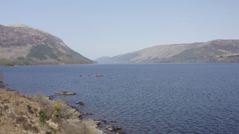 Canoeists in a Lake Surrounded by Forests and Mountains