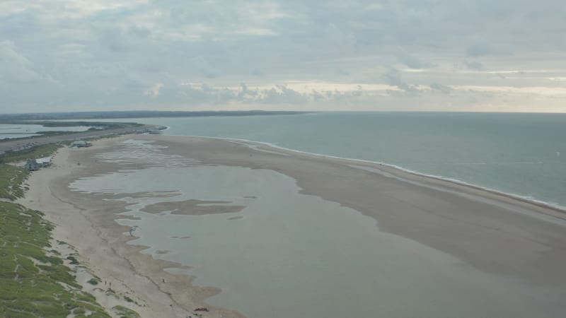 Establishing Aerial Wide View of North Sea Beach with Huge Water Puddles and Kitesurfers training