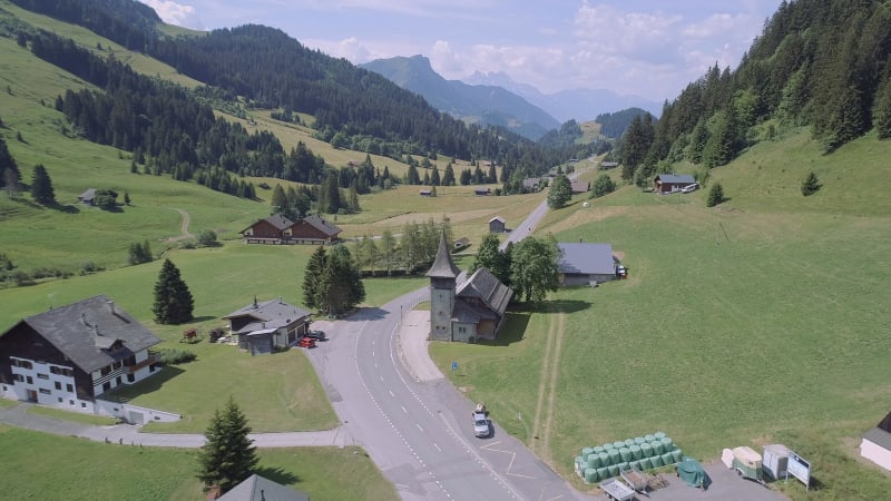 Aerial View of a Valley in Switzerland with Chalets and a Mountainous Landscape