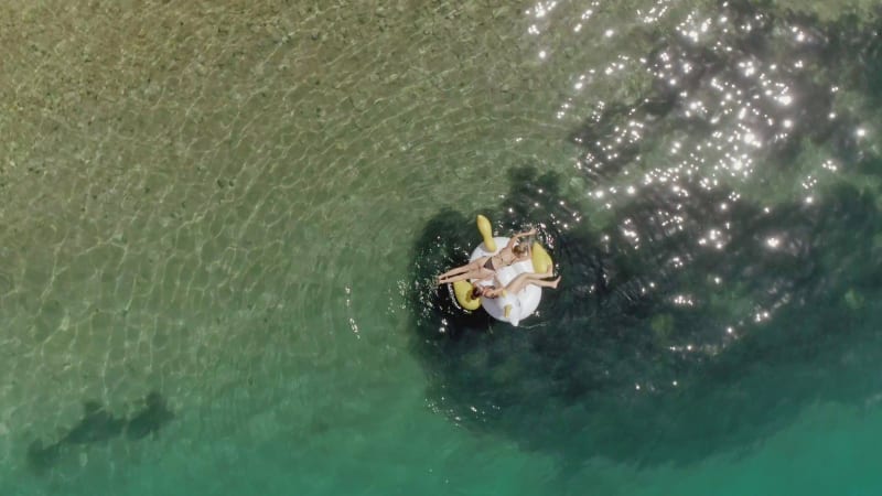 Aerial view of two women floating on inflatable in Panagopoula.