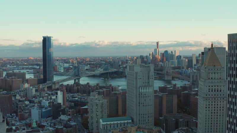 Aerial footage of large city and long cable-stayed bridges across river. Morning shot in sunrise time. Manhattan, New York City, USA