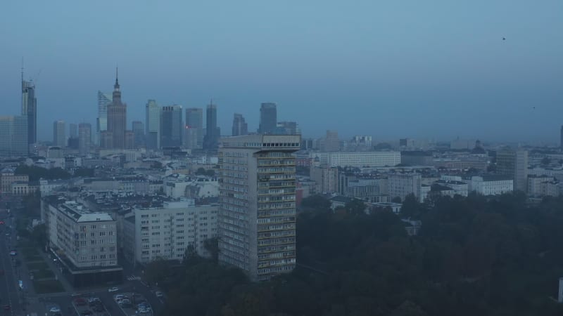 Pull back shot of Mlotek apartment house. Downtown skyline in background. Blue toned morning view. Warsaw, Poland