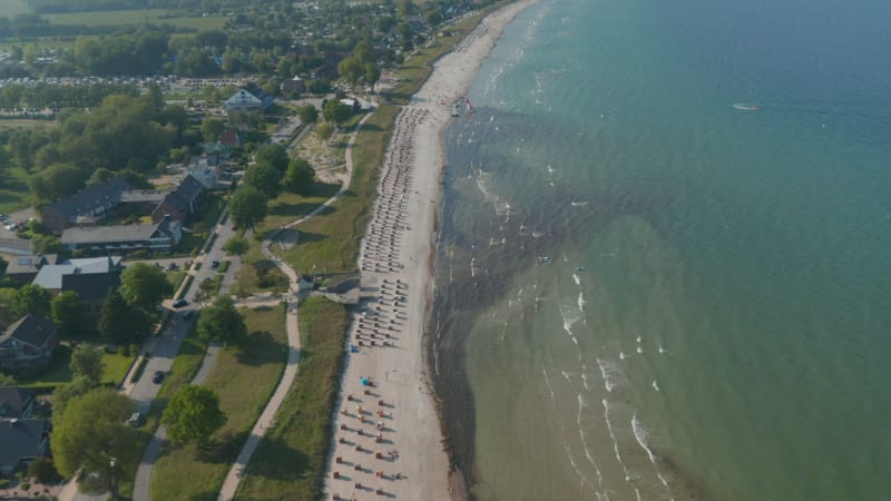 Majestic aerial drone view of travel destination tourist beach at Baltic sea in Scharbeutz, Germany, dolly in tilt down, day