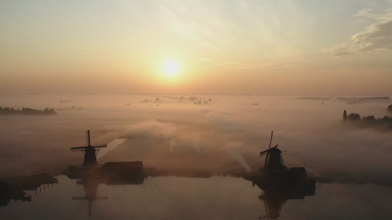 Stunning aerial view of the windmills in the fog