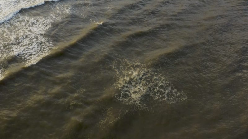 Close up view of a surfer riding on a windy dark waves