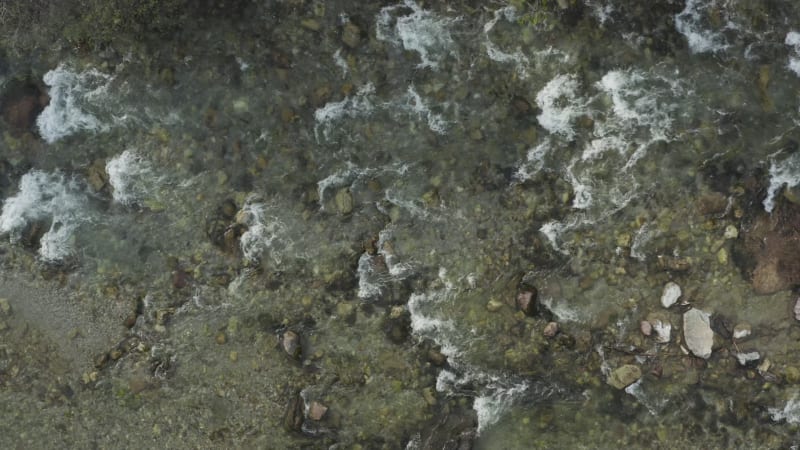 Clear mountain stream flowing over shallow rocky riverbed