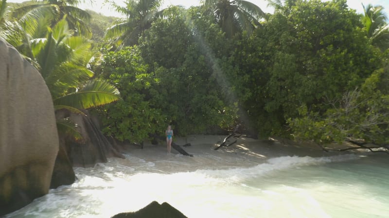 Aerial view of a woman on the rocks at Seychelles Island.