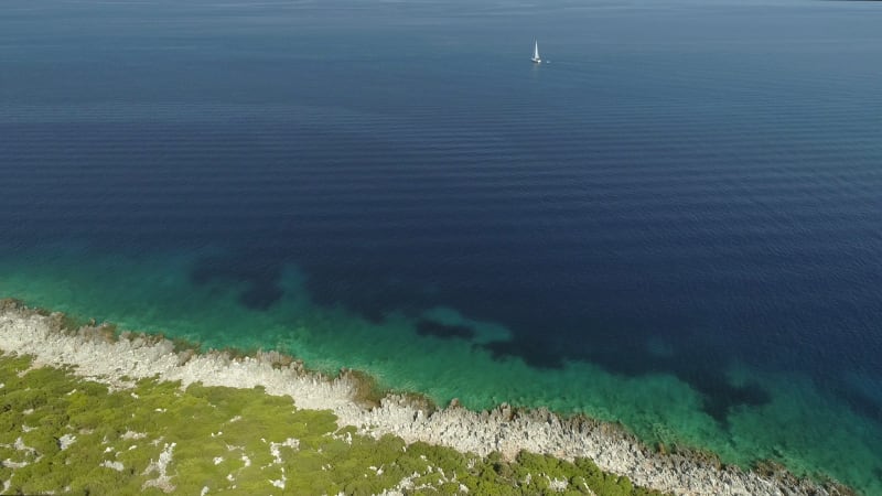 Aerial view of Lefkada island with a boat in the horizon.