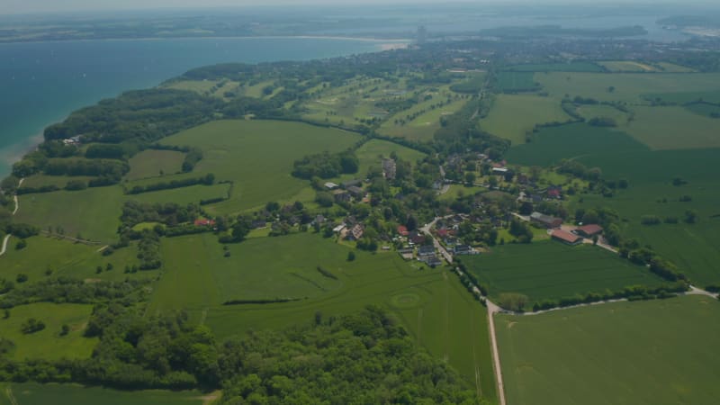 Beautiful aerial view landscape of Brodten, Germany, flying above buildings houses with Baltic sea on background, sunny day, circle pan