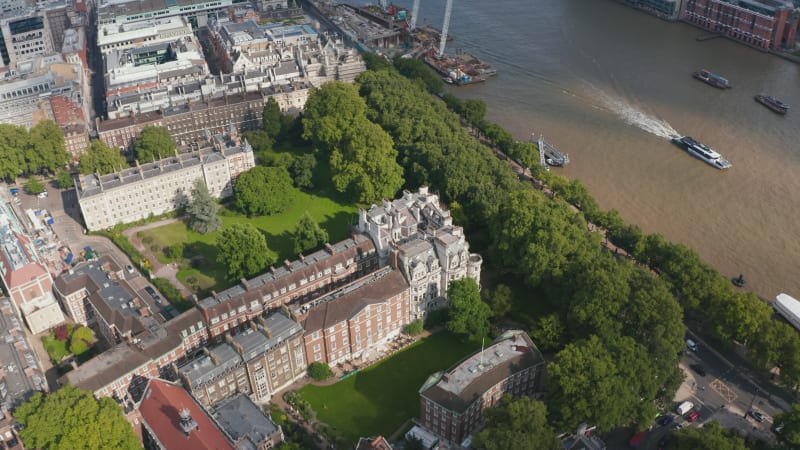 High angle view of historic buildings in Temple Gardens. Boat floating on water surface of River Thames. Sunny day in city. London, UK