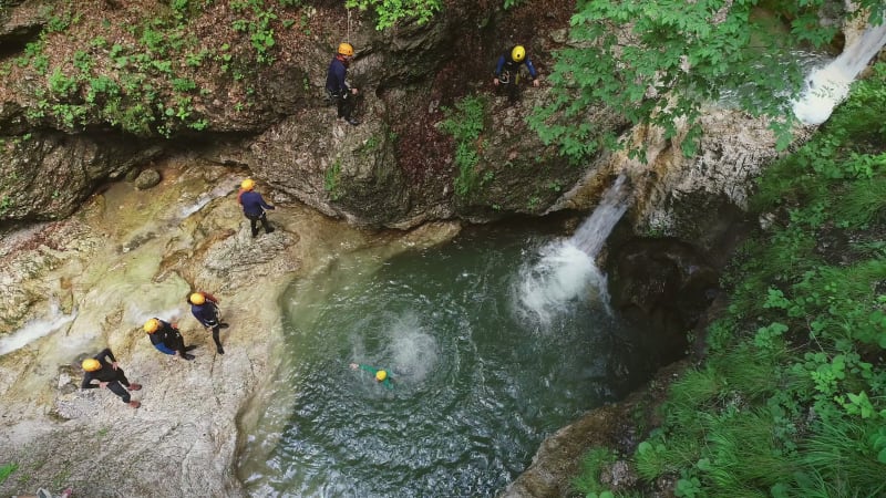 Aerial view of group of people jumping into the water.