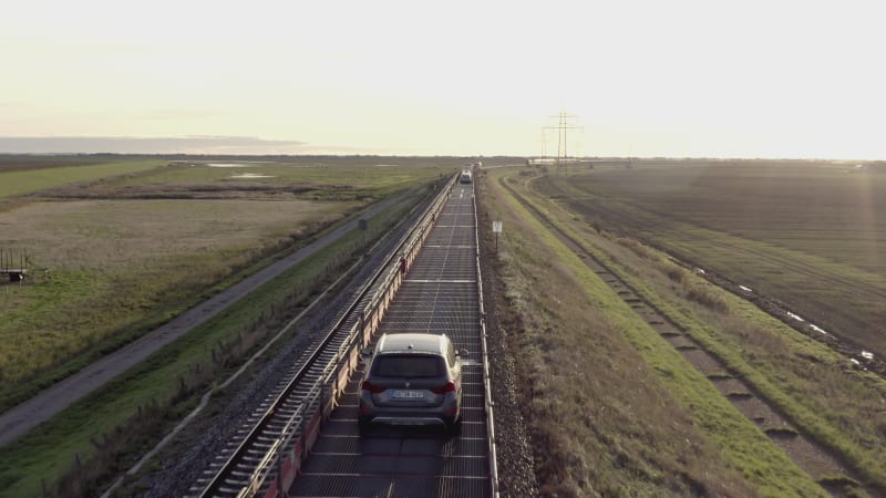 Moto Rail Train Carrying Vehicles and Passengers on a Journey