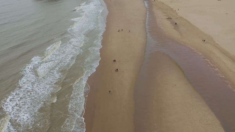 People walking on the beach on a cold autumn day