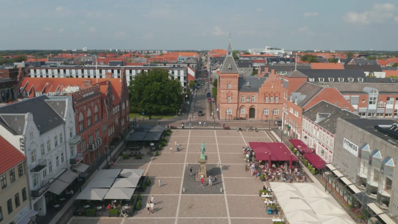 Flight over Torvet square in Esbjerg, Denmark with the statue of Christian IX and the Kommune, the Town Hall. Top down aerial view of Torvegade pedestrians street and scenic panorama of the city