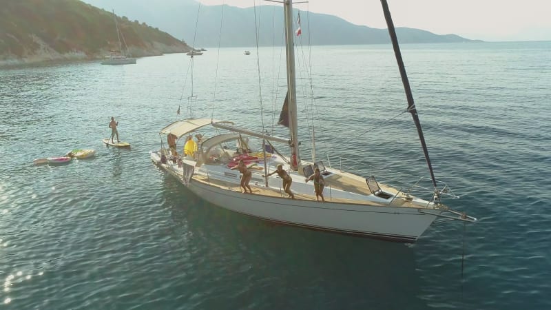 Aerial view of friends jumping from boat in the mediterranean sea.