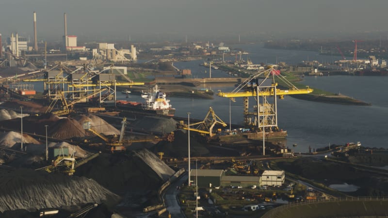 Spinning Wind Turbine Crosses Industrial Background