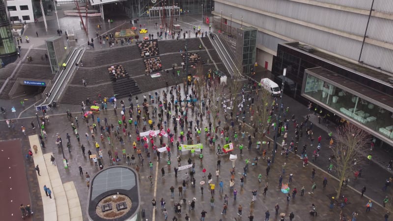 Ascending aerial drone footage of a climate strike on a rainy day in Utrecht, Netherlands.