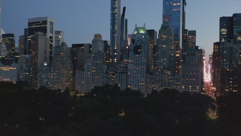 Scenic View of City Nightlife with bright flashing lights in Skyscraper Urban Canyon after Sunset in New York City, Aerial Wide Shot