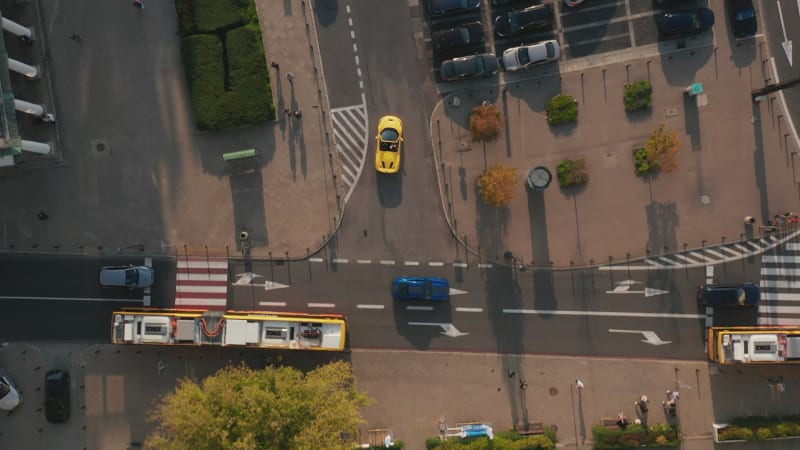 Aerial birds eye overhead top down view of traffic in streets of town centre. Tracking of yellow fast sports car. Warsaw, Poland