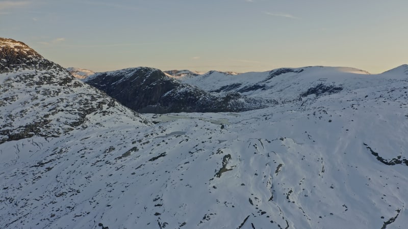 Snowy mountains with lake at sunset in Norway.