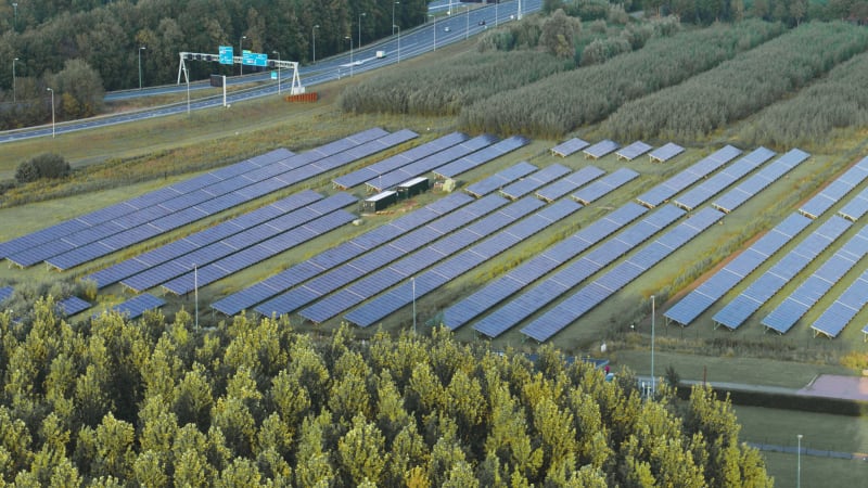 Aerial view of solar panels next to a highway