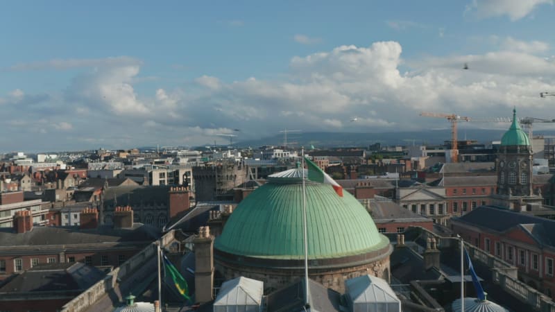 Pull back footage of City Hall. Historic building with green dome and national flag. Revealing buildings on waterfront. Dublin, Ireland