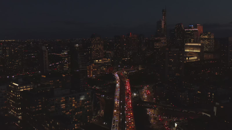 Aerial view of heavy traffic in streets of night town. High rise building with lighted windows. Brooklyn, New York City, USA