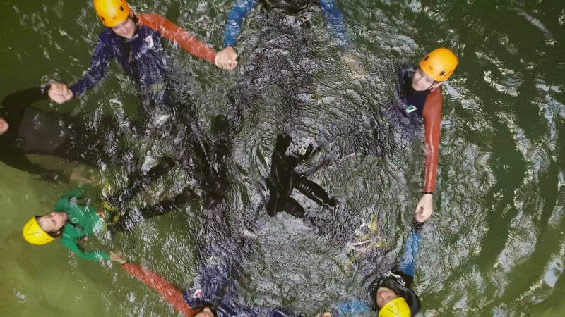 Aerial view of group of people forming a circle with their bodies.