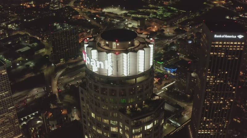 Downtown Los Angeles, California at Night, glowing city lights and Skyscraper Towers in metropolitan area with highway in background, Aerial View Circa 2019