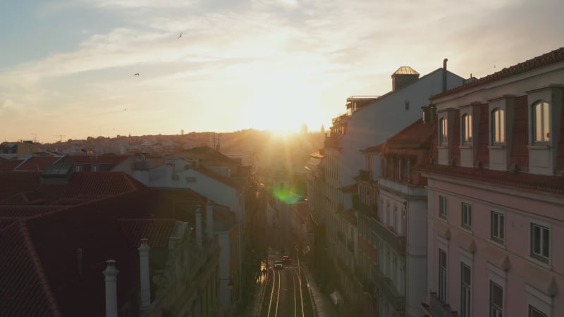 Aerial dolly in view of the quiet residential street and colorful houses in urban city center of Lisbon, Portugal during sunset