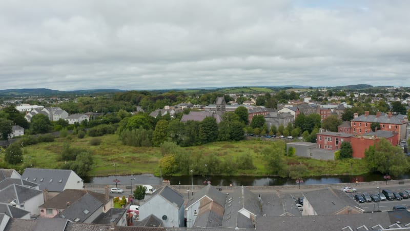 Aerial ascending footage of St Columbas Church. Old stone Anglican religious building surrounded by greenery. Ennis, Ireland