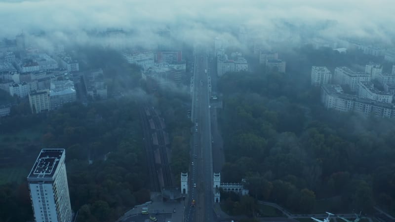 High angle view of wide street and railway track leading through town. Morning shot through sparse fog or low clouds. Warsaw, Poland