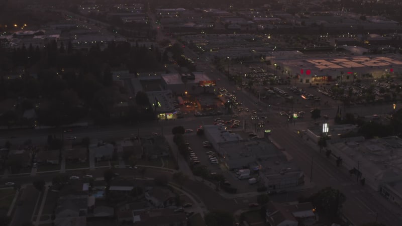 View of Culver City, Los Angeles, California traffic, intersection at dusk with car traffic passing and parking lot