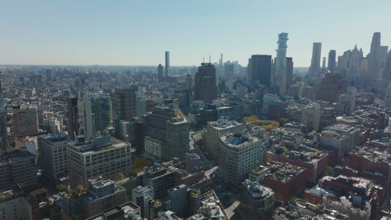 Slide and pan footage of buildings in city. Busy multilane road leading between blocks of multistorey buildings. Manhattan, New York City, USA