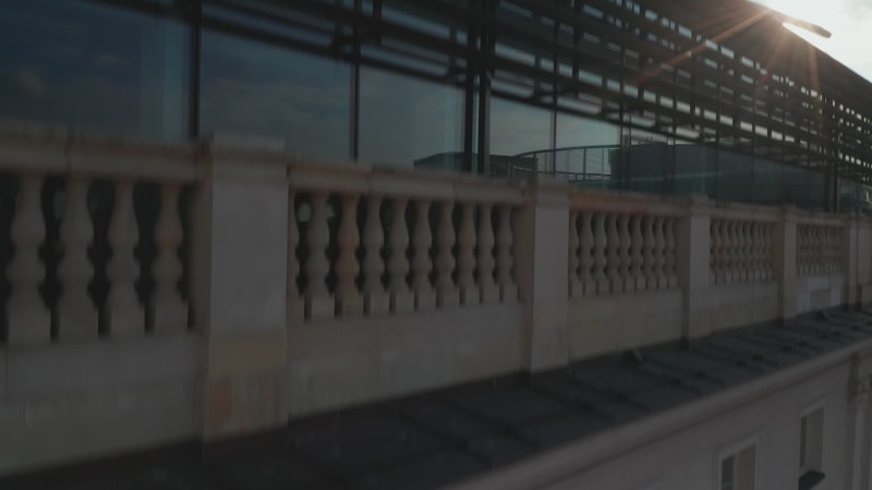 Ascending footage along building wall with windows. Revealing Pilsudski Square and skyline with high rise buildings. Warsaw, Poland