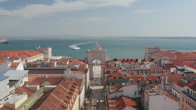 Aerial view of historic town center, King Pedro IV Square with Column of Pedro IV and Queen Maria II National Theatre. Drone camera flying forward and tilts down. Lisbon, capital of Portugal.