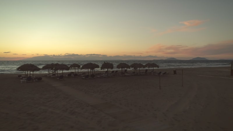 Aerial view of a empty sandy beach at sunset.