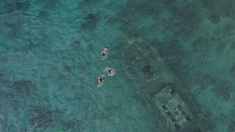 Aerial View of Three Swimmers at a Shipwreck in Curacao, Dutch Caribbean