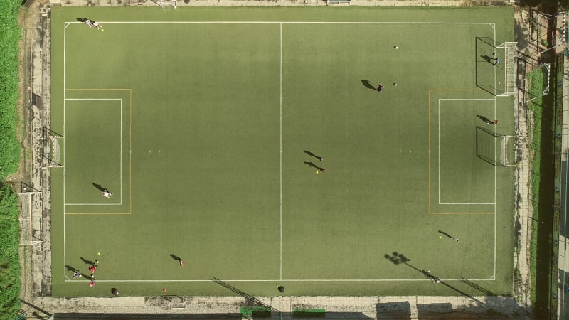 Aerial view of people training football in a beautiful football camp.