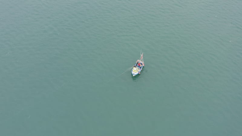 Fishing Boat Pulling Nets on a Grey Day From the Air