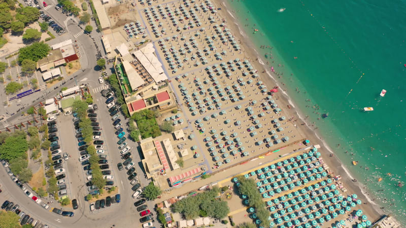 Aerial view of crowded beach full of umbrellas during the day.