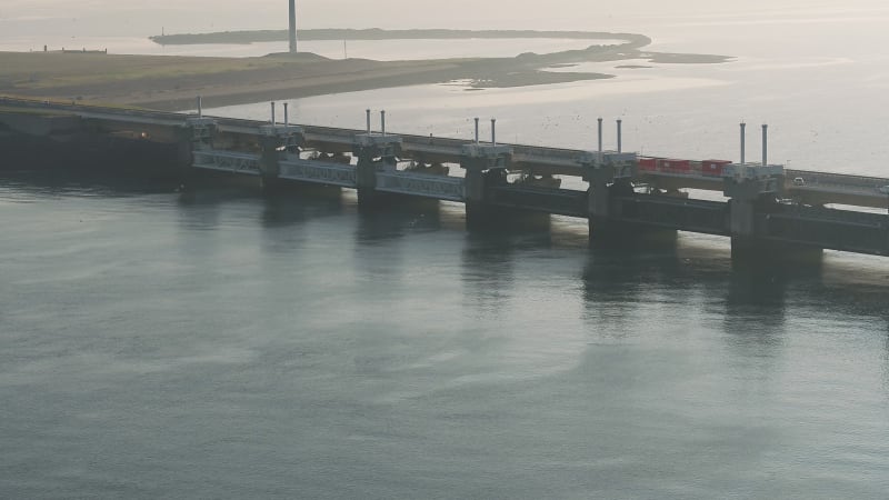 Birds flying around storm surge barrier bridge by the sea