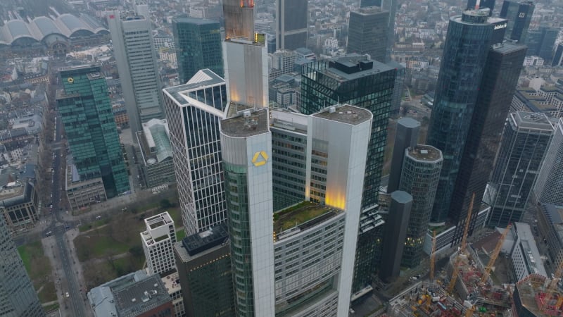 Pull back shot of top part of Commerzbank Tower. tilt up reveal downtown skyscrapers and hazy view of cityscape. Frankfurt am Main, Germany