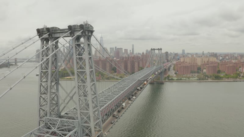 Flight over Williamsburg Bridge Brooklyn side with Car traffic and streets at cloudy day