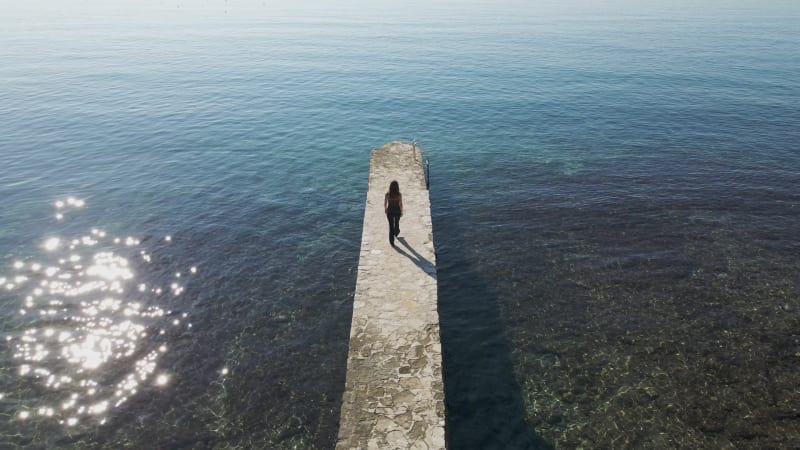 Aerial view of a woman walking on the pier, Istria, Croatia.