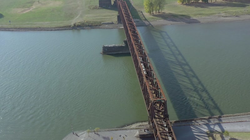 Commuter Train Passing Fast Over an Old Iron Bridge