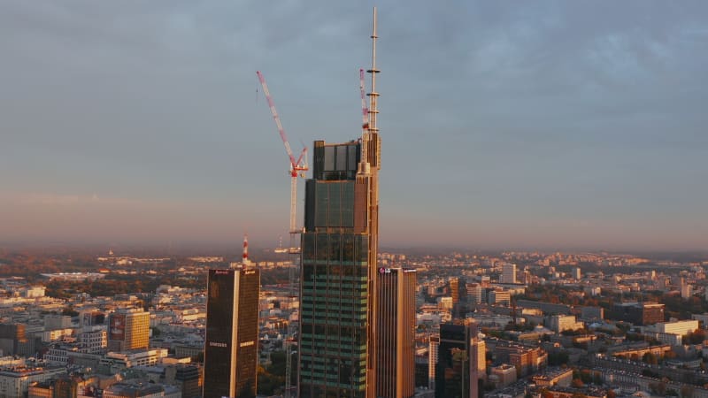 Morning forwards fly towards construction site of tall downtown office of apartment building. Warsaw, Poland