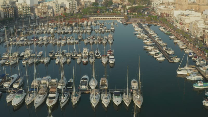 Sailboats in the Harbour of small town on Malta Island, Aerial tilt down view