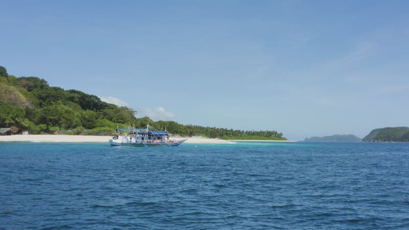 Low shot approaching a boat anchored off island in Philippines