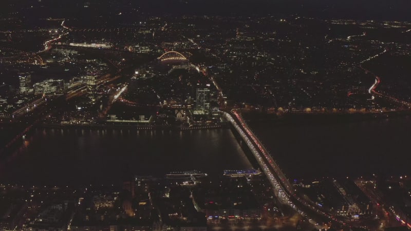 AERIAL: Beautiful Wide Shot over Cologne Germany at Night time with City lights